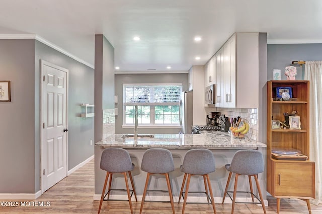 22 Commons Dr, Neptune Township, NJ 07753 - kitchen with stainless steel appliances, backsplash, light stone counters, ornamental molding, and white cabinets