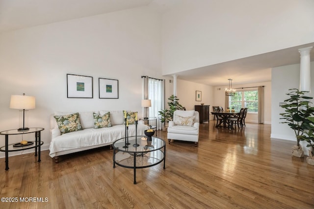 30 Thousand Oaks Ter, Howell, NJ 07731 - living area with wood finished floors, baseboards, a chandelier, a high ceiling, and ornate columns