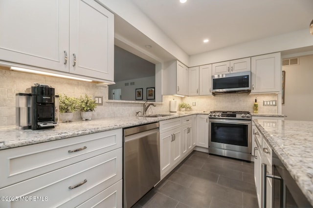 30 Thousand Oaks Ter, Howell, NJ 07731 - kitchen featuring stainless steel appliances, a sink, dark tile patterned floors, decorative backsplash, and white cabinetry