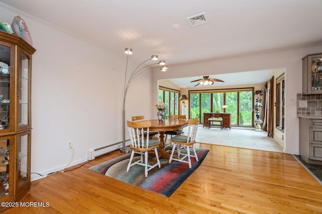 668 Clifton Ave, Toms River, NJ 08753 - dining room with a baseboard heating unit, light wood finished floors, ceiling fan, ornamental molding, and baseboards