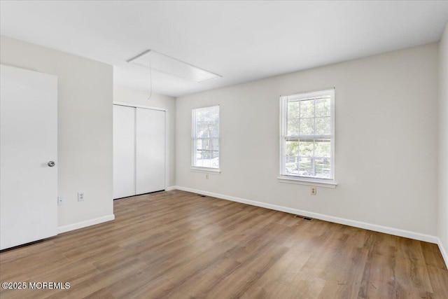 48 Scarborough Ct Unit 7, Freehold, NJ 07728 - unfurnished bedroom with attic access, wood finished floors, baseboards, and a closet