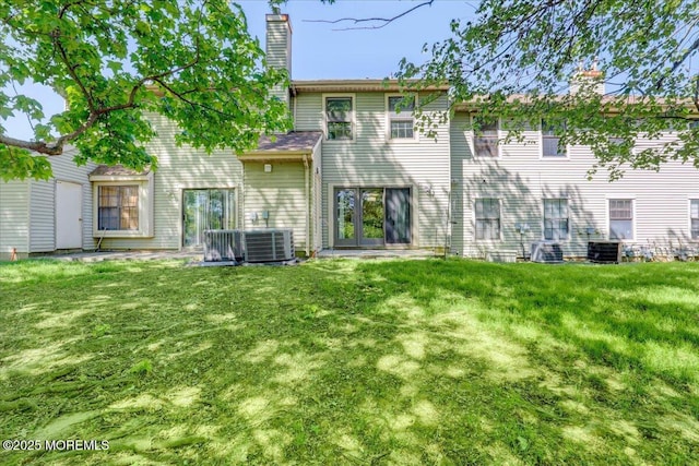 48 Scarborough Ct Unit 7, Freehold, NJ 07728 - rear view of property featuring a chimney, a yard, and central AC
