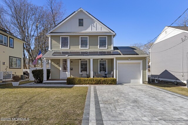 11 Clay St, West Long Branch, NJ 07764 - view of front facade with a porch, decorative driveway, a garage, solar panels, and board and batten siding