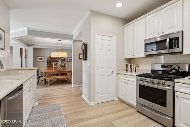 33 Cooper Ave Unit 401, Long Branch, NJ 07740 - kitchen with appliances with stainless steel finishes, a sink, crown molding, backsplash, and white cabinetry
