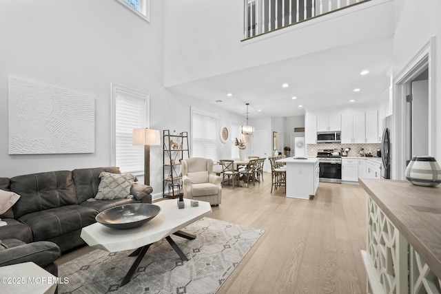 115 Hedgerow Ln, Manalapan, NJ 07726 - living room with light wood-type flooring, a towering ceiling, and recessed lighting