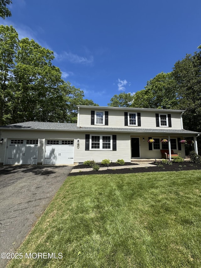 63 1st St, Barnegat, NJ 08005 - traditional-style home featuring asphalt driveway, a front lawn, a garage, and covered porch