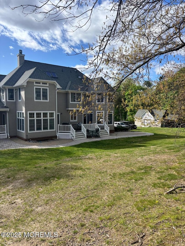 231 Friendship Rd, Howell, NJ 07731 - rear view of house with a patio, a chimney, and a yard