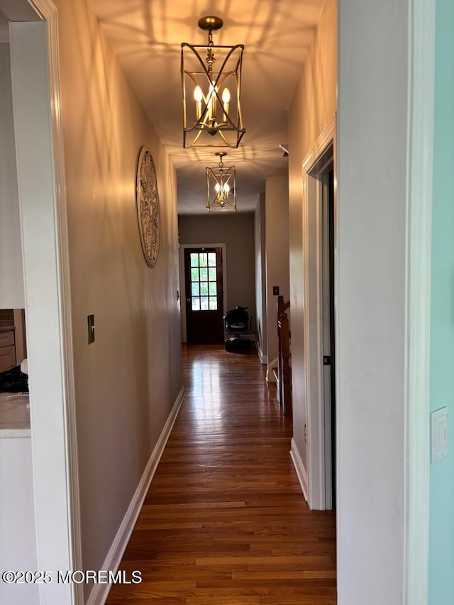 231 Friendship Rd, Howell, NJ 07731 - hall featuring a chandelier, dark wood-type flooring, and baseboards