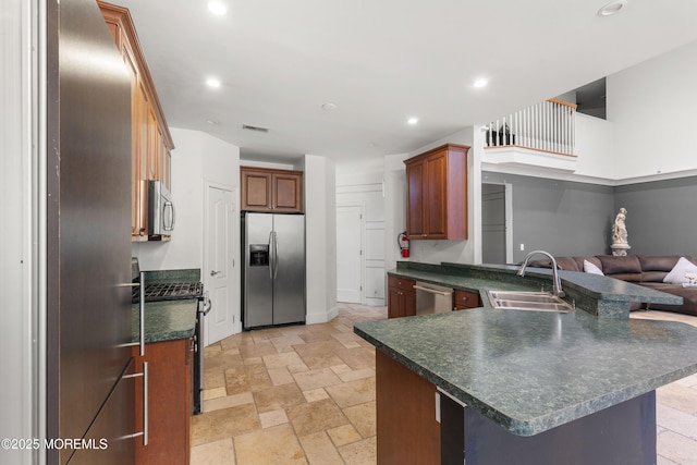 17 Meadow Run Ct, Jackson, NJ 08527 - kitchen with stainless steel appliances, a sink, dark countertops, a peninsula, and stone tile floors