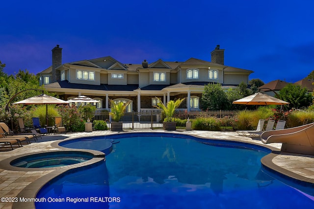 211 Cedar Ave, Long Branch, NJ 07740 - pool at twilight featuring a water slide, a patio, and a pool with connected hot tub