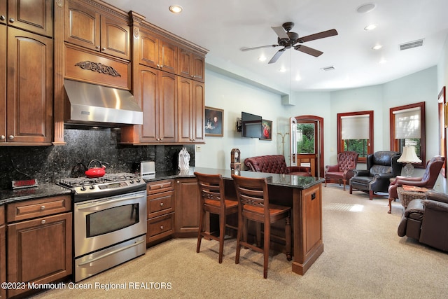211 Cedar Ave, Long Branch, NJ 07740 - kitchen with gas range, under cabinet range hood, open floor plan, a peninsula, and light colored carpet