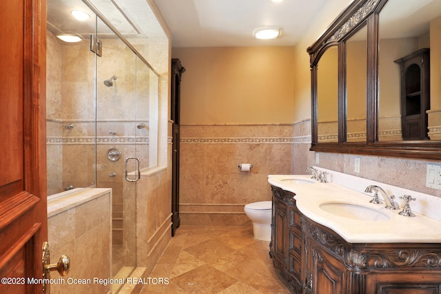211 Cedar Ave, Long Branch, NJ 07740 - full bath with a shower stall, toilet, double vanity, wainscoting, and tile walls