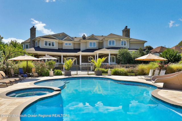 211 Cedar Ave, Long Branch, NJ 07740 - view of swimming pool featuring a water slide, a patio area, and a pool with connected hot tub