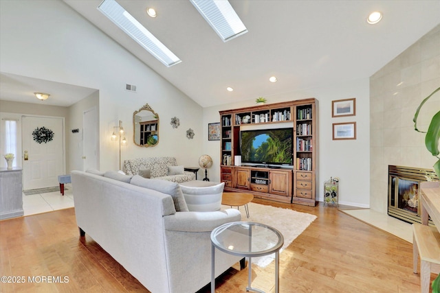 56 Hazel Dr, Freehold, NJ 07728 - living area with light wood-style flooring, recessed lighting, a tile fireplace, a skylight, and high vaulted ceiling