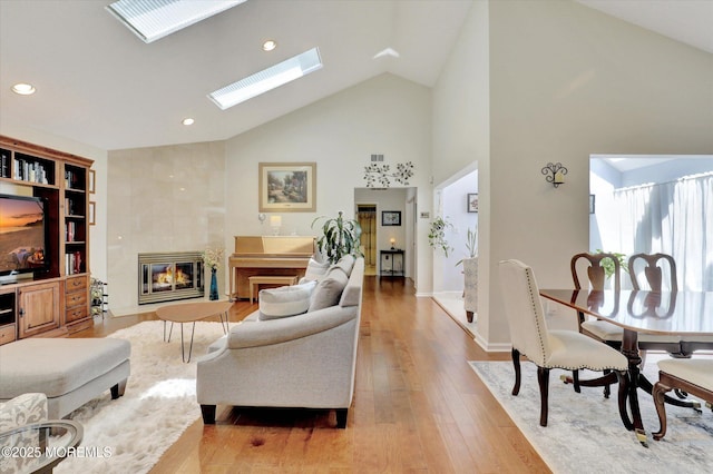 56 Hazel Dr, Freehold, NJ 07728 - living room with a tiled fireplace, high vaulted ceiling, light wood-style flooring, a skylight, and recessed lighting