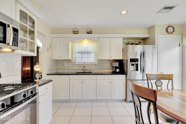 56 Hazel Dr, Freehold, NJ 07728 - kitchen with appliances with stainless steel finishes, a sink, glass insert cabinets, white cabinetry, and decorative backsplash