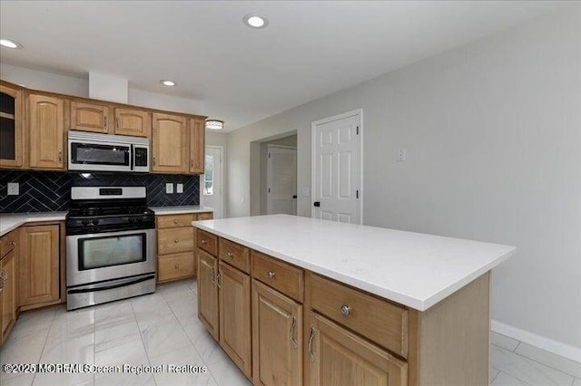 110 Island Rd, Toms River, NJ 08753 - kitchen featuring stainless steel appliances, light countertops, light marble finish flooring, tasteful backsplash, and a kitchen island