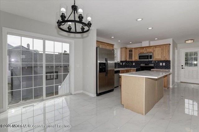 110 Island Rd, Toms River, NJ 08753 - kitchen featuring stainless steel appliances, a chandelier, backsplash, light marble finish flooring, and brown cabinetry