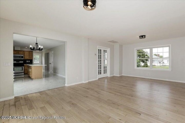 110 Island Rd, Toms River, NJ 08753 - unfurnished living room featuring a chandelier, light wood-style flooring, and baseboards