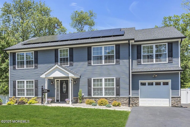 119 Darien Rd, Howell, NJ 07731 - view of front of home with stone siding, a front yard, roof mounted solar panels, and driveway