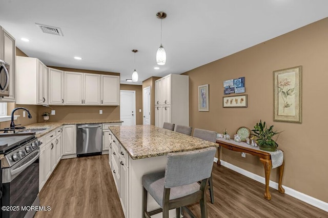 119 Darien Rd, Howell, NJ 07731 - kitchen featuring stainless steel appliances, a sink, baseboards, wood finished floors, and a breakfast bar area