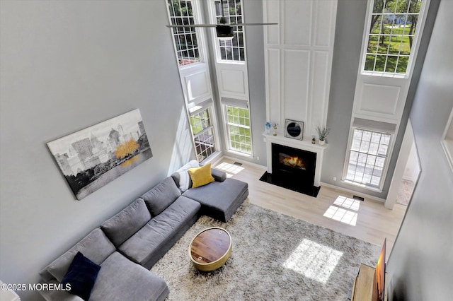 64 Sage St, Holmdel, NJ 07733 - living room with a high ceiling, wood finished floors, and a fireplace with flush hearth