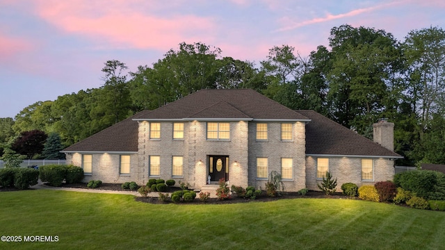 21 Windswept Ln, Freehold, NJ 07728 - colonial house with a lawn, a chimney, and brick siding