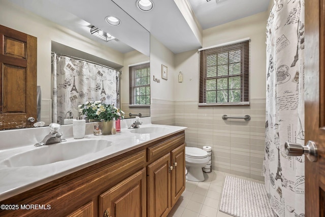 21 Windswept Ln, Freehold, NJ 07728 - bathroom featuring tile patterned floors, toilet, double vanity, tile walls, and wainscoting