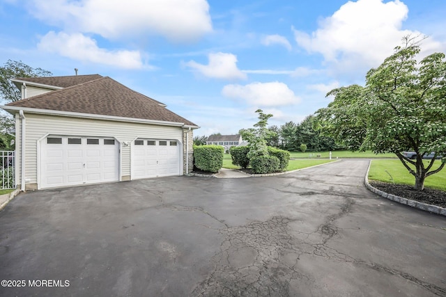 21 Windswept Ln, Freehold, NJ 07728 - view of side of property featuring driveway, a lawn, roof with shingles, and a garage