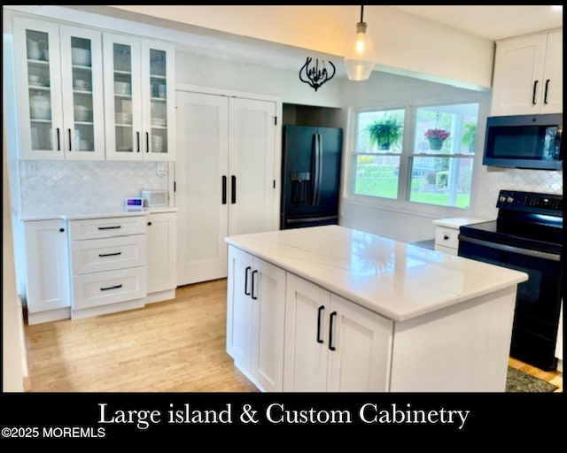 123 France St, Toms River, NJ 08753 - kitchen with black appliances, white cabinetry, tasteful backsplash, and light wood finished floors