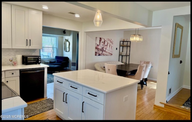 123 France St, Toms River, NJ 08753 - kitchen featuring black dishwasher, light wood-style floors, white cabinets, a chandelier, and hanging light fixtures
