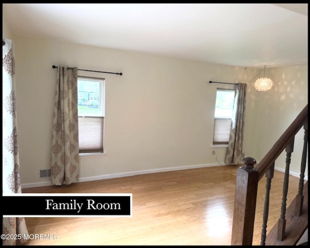 123 France St, Toms River, NJ 08753 - unfurnished room featuring wood finished floors, a chandelier, baseboards, and stairway