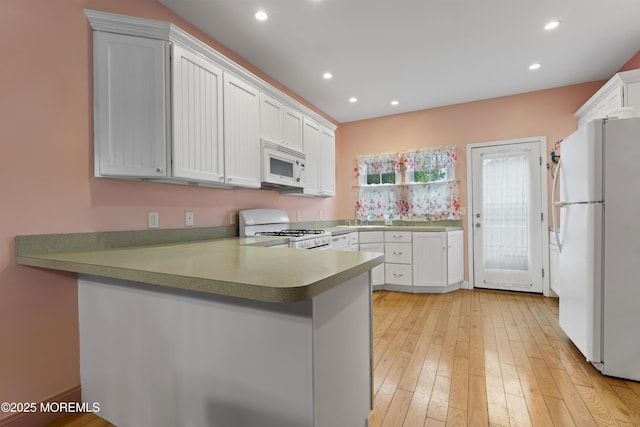 134 Franklin Ave, Ocean Grove, NJ 07756 - kitchen with white appliances, a peninsula, recessed lighting, light wood-style flooring, and white cabinets