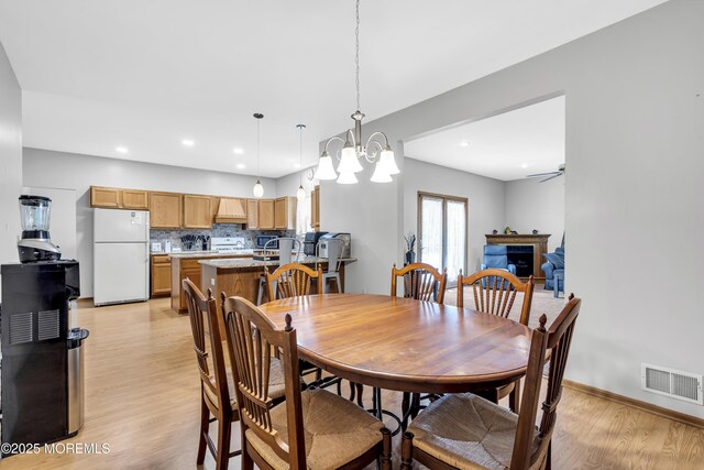 1 Overlook Ct, Manchester, NJ 08759 - dining area with light wood-style floors, ceiling fan, a chandelier, a fireplace, and baseboards