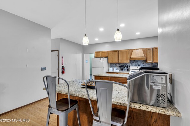 1 Overlook Ct, Manchester, NJ 08759 - kitchen featuring custom exhaust hood, light wood finished floors, freestanding refrigerator, brown cabinetry, and decorative backsplash