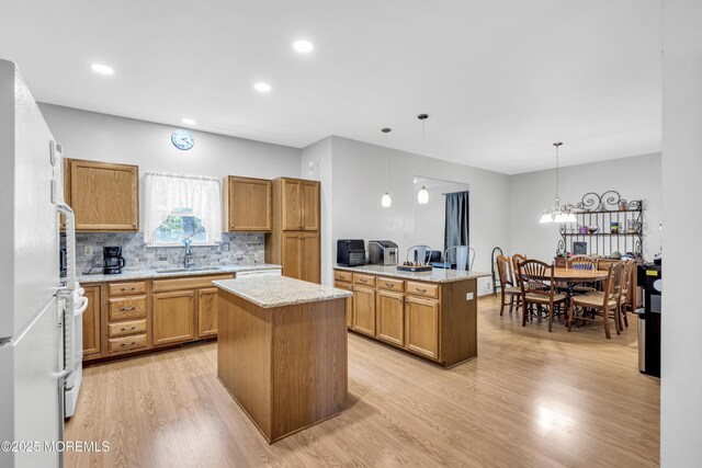 1 Overlook Ct, Manchester, NJ 08759 - kitchen with a sink, light wood-style flooring, a peninsula, a center island, and brown cabinetry