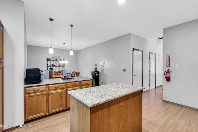 1 Overlook Ct, Manchester, NJ 08759 - kitchen featuring light wood finished floors, brown cabinets, light stone countertops, pendant lighting, and a center island
