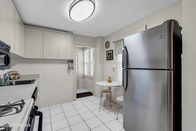 54 Wall St, West Long Branch, NJ 07764 - kitchen featuring freestanding refrigerator, a sink, tile walls, light tile patterned floors, and light countertops