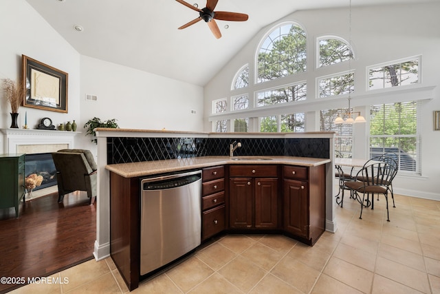 38 Point Pleasant Ln, Waretown, NJ 08758 - kitchen featuring stainless steel dishwasher, a sink, a ceiling fan, light countertops, and a tile fireplace
