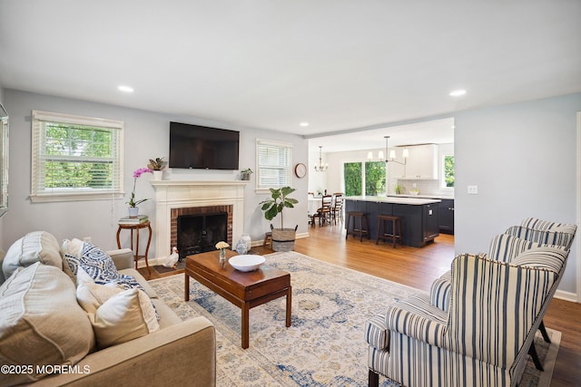 177 Cambridge Ave, Fair Haven, NJ 07704 - living room featuring healthy amount of natural light, a chandelier, light wood-style flooring, a fireplace, and recessed lighting