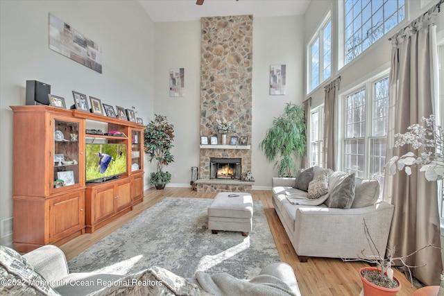 11 Elkridge Way, Manalapan, NJ 07726 - living room featuring a high ceiling, wood finished floors, a stone fireplace, baseboards, and ceiling fan