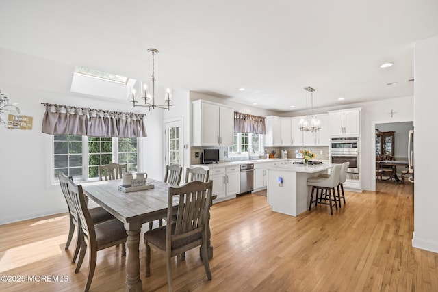 11 Elkridge Way, Manalapan, NJ 07726 - dining area with a chandelier, light wood finished floors, a skylight, recessed lighting, and baseboards