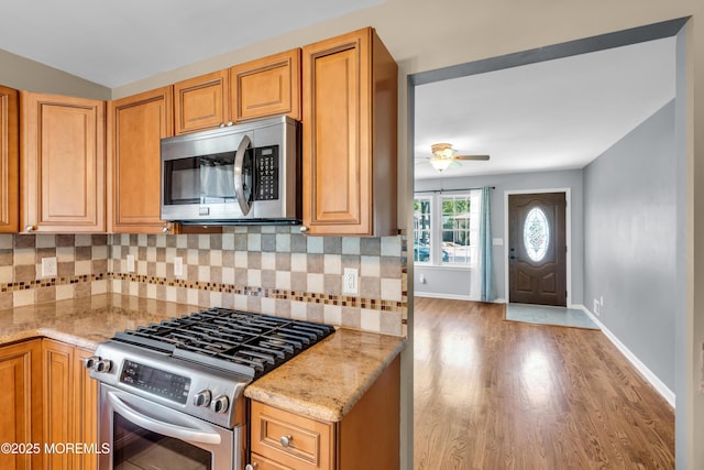 9 Fullerton Dr, Brick, NJ 08723 - kitchen featuring appliances with stainless steel finishes, light stone counters, a ceiling fan, and light wood-style floors