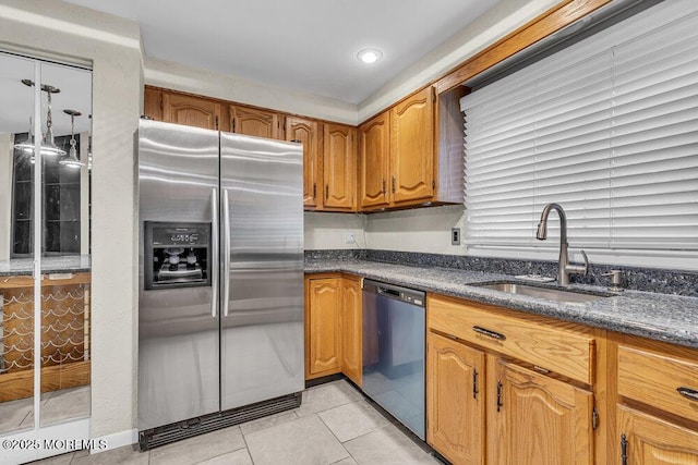 3 Black Pine Ln, Brielle, NJ 08730 - kitchen featuring appliances with stainless steel finishes, a sink, light tile patterned floors, brown cabinets, and dark stone counters