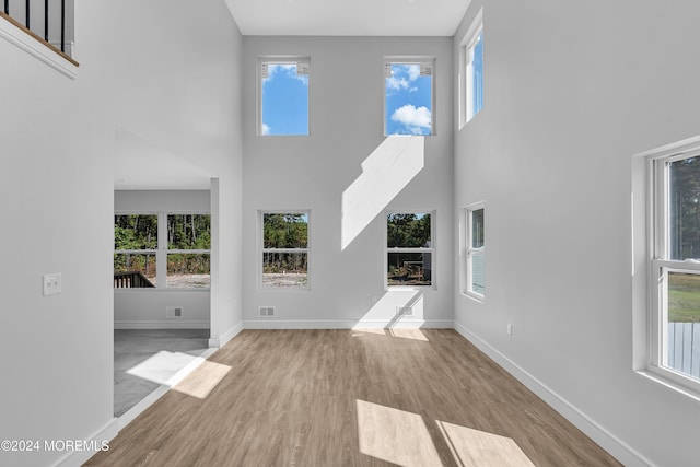 169 Grand Central Pkwy, Bayville, NJ 08721 - unfurnished living room featuring a towering ceiling, wood finished floors, and baseboards