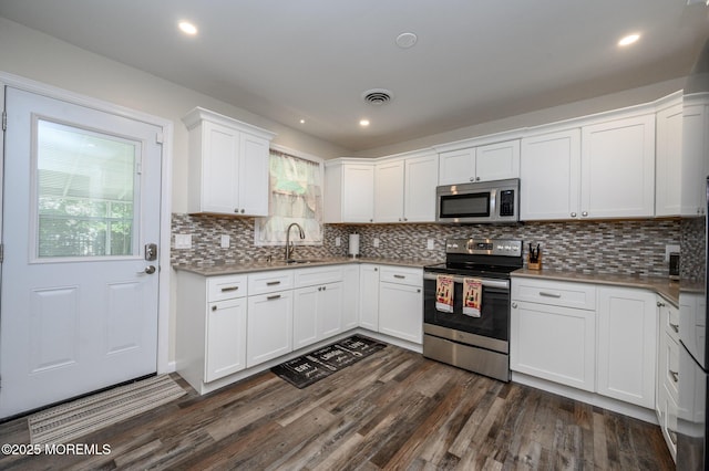 1A Winthrop Pl Unit 55, Whiting, NJ 08759 - kitchen with appliances with stainless steel finishes, dark wood finished floors, white cabinetry, decorative backsplash, and recessed lighting