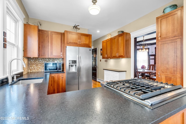 89 Heck Ave, Ocean Grove, NJ 07756 - kitchen featuring appliances with stainless steel finishes, a sink, dark countertops, a chandelier, and tasteful backsplash