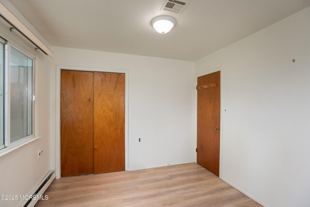 343 Barbados Dr N, Toms River, NJ 08757 - unfurnished bedroom with a closet, light wood-style floors, a baseboard heating unit, and baseboards