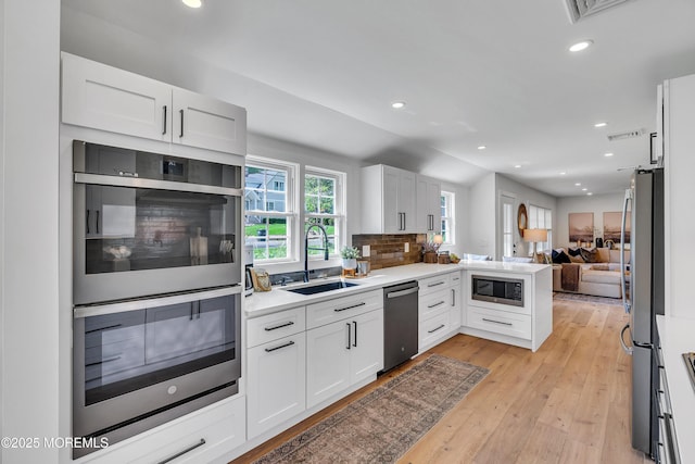 2574 Algonkin Trl, Manasquan, NJ 08736 - kitchen featuring a sink, appliances with stainless steel finishes, open floor plan, white cabinets, and recessed lighting