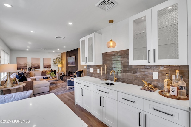 2574 Algonkin Trl, Manasquan, NJ 08736 - kitchen featuring a sink, decorative light fixtures, dark wood finished floors, backsplash, and white cabinetry